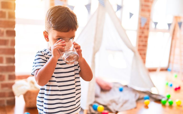 child drinking a glass of water