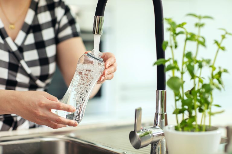 girl pouring water into a bottle