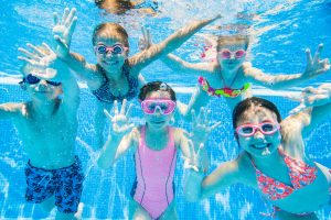 Little kids swimming in pool underwater